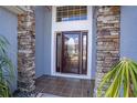 Inviting front door with decorative glass, stone pillars, and tile entry at 2706 Rochelle Dr, Winter Haven, FL 33881