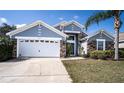 Attractive single-story home featuring stone accents, an attached garage, and front yard landscaping at 2706 Rochelle Dr, Winter Haven, FL 33881