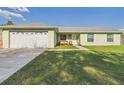 Charming single-story home with a well-manicured lawn and a two-car garage at 31 Wagon Cir, Kissimmee, FL 34743