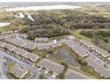 Overhead shot of multiple townhomes in a neighborhood with ponds and dense tree coverage at 4084 Winding Vine Dr, Lakeland, FL 33812