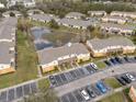 Aerial view of residential area with pond, parking lot, and several buildings in the community at 4084 Winding Vine Dr, Lakeland, FL 33812