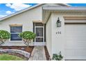 Inviting front entrance with a decorative glass door, stone pathway, and manicured shrubbery around the house number at 496 Lake Suzanne Dr, Lake Wales, FL 33859
