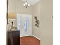 Bright foyer with decorative lighting, stylish console table, and elegant front door with glass detailing at 496 Lake Suzanne Dr, Lake Wales, FL 33859