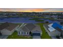 Aerial view of a cozy home with a gray roof overlooking a serene pond in the neighborhood at 5767 Lakeside Landings Blvd, Winter Haven, FL 33881