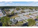 Aerial view of a cozy home featuring a covered parking area and sunroom in a friendly neighborhood at 6053 Southern Oaks Se Dr, Winter Haven, FL 33884