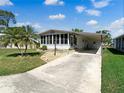 Well-maintained single-story home with a carport and a charming Florida room under a sunny blue sky at 6053 Southern Oaks Se Dr, Winter Haven, FL 33884