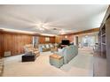 Spacious living room featuring wood paneled walls and carpet flooring at 660 Duggers Way, Lake Wales, FL 33859