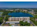 Scenic aerial view of the condo, lake, and surrounding neighborhood at 700 Mirror Nw Ter # 111, Winter Haven, FL 33881