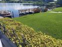 Beautiful waterfront view with a dock, boat, and lush greenery at 700 Mirror Nw Ter # 111, Winter Haven, FL 33881