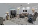 Inviting living room featuring a comfortable gray sofa, TV, and cozy lighting at 734 Canberra Rd, Winter Haven, FL 33884