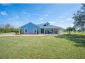 Beautiful single-story home boasting a manicured lawn and charming blue exterior at 9461 Redhawk Bend Ln, Lakeland, FL 33810