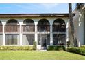 Back view of condo featuring a screened-in porch, well-maintained landscaping and manicured lawn at 1103 Country Club Dr # A-3, Lake Wales, FL 33898