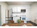 Bright kitchen with stainless steel refrigerator, white cabinetry, range, and microwave at 1325 4Th Ne St, Winter Haven, FL 33881