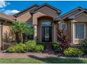 Close up of the front of the home featuring a beautiful front door and lush landscaping at 1336 Oakmont Dr, Winter Haven, FL 33884