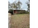Modest single-story home with brick facade and mature trees in an established neighborhood at 201 Cleveland Avenue, Winter Haven, FL 33881