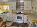 Traditional kitchen with white cabinetry, standard appliances, and laminate countertops at 201 Cleveland Avenue, Winter Haven, FL 33881