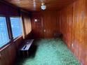 Enclosed front porch area featuring wood paneling, an entry door, and multiple windows at 201 Cleveland Avenue, Winter Haven, FL 33881