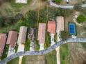 Birds-eye view of a home with a terracotta roof and mature landscaping near a tennis court at 20143 Sunset Landing Ave, Groveland, FL 34736