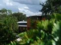 Modern home partially obscured by lush, tropical vegetation at 2300 N Scenic Hwy # 120, Lake Wales, FL 33898