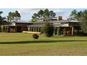 Expansive lawn and modern single story home with a metal roof at 2300 N Scenic Hwy # 120, Lake Wales, FL 33898