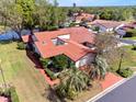 An aerial view of the home shows well-manicured landscaping and a tile roof near a tranquil pond at 2637 Sunburst Ct, Lake Wales, FL 33898