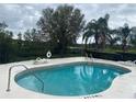 Relaxing community pool with lake view featuring lounge chairs and a secure fenced perimeter at 2723 Rutledge Ct, Winter Haven, FL 33884