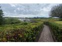 Brick path leading to a peaceful lake overlook surrounded by lush green landscaping at 2723 Rutledge Ct, Winter Haven, FL 33884