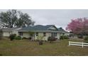 Expansive backyard with mature trees and white picket fence, perfect for outdoor activities at 3065 E Central Ave, Bartow, FL 33830