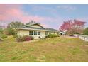 Inviting exterior with lush landscaping, blooming tree, and well-maintained lawn at 3065 E Central Ave, Bartow, FL 33830