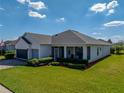 Well-maintained home with a lush lawn, manicured bushes, and a screened-in porch for outdoor enjoyment at 3686 Plymouth Dr, Winter Haven, FL 33884