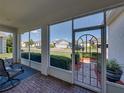 View from the screened front porch highlighting brick flooring, secure screen door, and neighborhood views at 3686 Plymouth Dr, Winter Haven, FL 33884