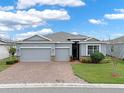 Charming single-Gathering home with a brick driveway, a well-manicured lawn, and a neutral-colored exterior at 3711 Plymouth Dr, Winter Haven, FL 33884
