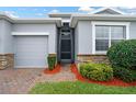 Inviting front entryway with a decorative stone accent, lush landscaping, and a modern front door at 3711 Plymouth Dr, Winter Haven, FL 33884