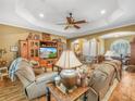 Inviting living room with wood floors, a tray ceiling, and comfortable leather seating at 4073 Sable Loop Dr, Lake Wales, FL 33859