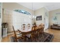 Formal dining room featuring hardwood floors, a large window, a chandelier, and seating for eight at 415 Ruby Lake Pl, Winter Haven, FL 33884