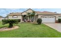 Beautiful single-story house with a well maintained lawn, palm trees, and an attached two-car garage at 415 Ruby Lake Pl, Winter Haven, FL 33884