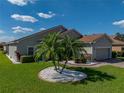 Beautifully landscaped front yard featuring lush green grass, a palm tree, and a well-maintained exterior at 5304 Nicklaus Dr, Winter Haven, FL 33884