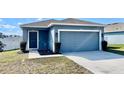 Single-story home featuring blue siding, a two-car garage, and a well-maintained lawn at 663 Lucerne Blvd, Winter Haven, FL 33881