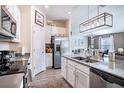 Modern kitchen with stainless steel appliances, gray countertops, white cabinets, and an island with a sink at 708 Simone Ct, Haines City, FL 33844