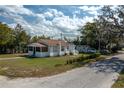 Exterior showcasing the side and rear of a one-story home with a screened porch and detached storage shed at 750 Avenue O Sw, Winter Haven, FL 33880