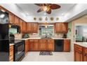 Well-equipped kitchen boasts granite countertops, wooden cabinets, and modern appliances, including a black oven and dishwasher at 762 Canberra Rd, Winter Haven, FL 33884