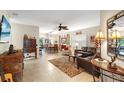 Spacious living room featuring tile floors, a ceiling fan, and a comfortable seating area, with an open view to the dining area at 762 Canberra Rd, Winter Haven, FL 33884