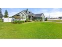 Well-maintained lawn, manicured landscaping, a two-car garage and fenced in yard enhance the curb appeal of this home at 819 Hart Lake St, Winter Haven, FL 33884