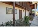Condo entrance with a wood door, exterior stairs, and neat landscaping at 1104 Country Club Dr # A-4, Lake Wales, FL 33898