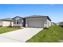 Charming single-Gathering home featuring a driveway, lush lawn, and inviting facade at 1340 Oak Valley Drive, Auburndale, FL 33823