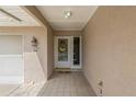 Inviting covered entryway features a tiled floor, textured walls, and decorative floral wreath on the front door at 1447 Kingfish Ln, Winter Haven, FL 33884