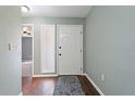 Entryway with hardwood floors, soft green walls, and a white front door creating a warm and inviting atmosphere at 1447 Kingfish Ln, Winter Haven, FL 33884