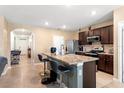Eat-in kitchen featuring an island with breakfast bar, dark wood cabinets and stainless steel appliances at 148 Emanuelle Dr, Winter Haven, FL 33884