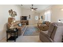 Cozy living room with plush seating, ceiling fan, and neutral carpet at 1822 Nicaragua Way, Winter Haven, FL 33881