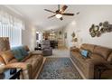 Spacious living room featuring leather sofas, a ceiling fan, and a decorative rug at 1822 Nicaragua Way, Winter Haven, FL 33881
